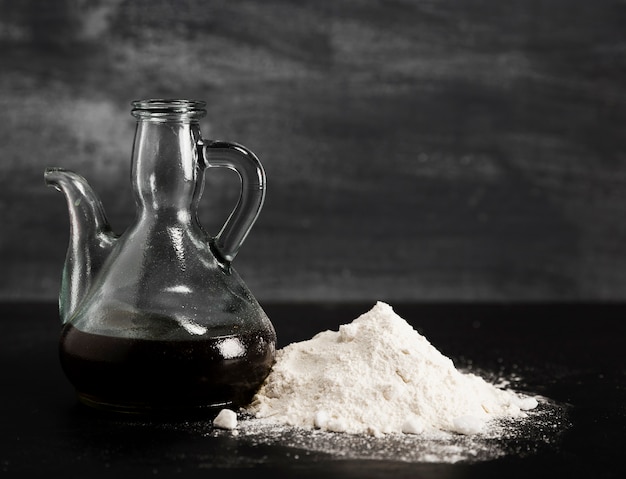 Free photo modern jug with melted chocolate and stack of powdered sugar