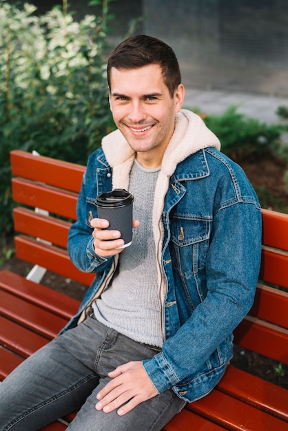 Free Photo modern man sitting on bench in urban environment