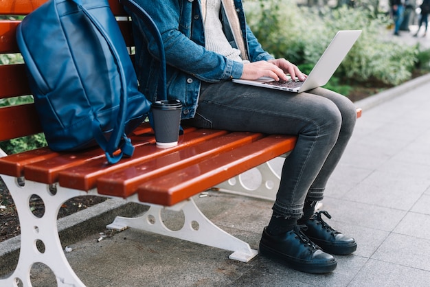 Modern man sitting on bench in urban environment