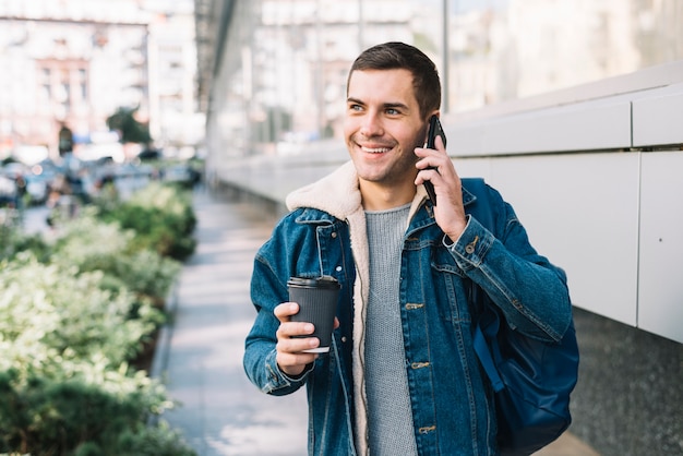 Modern man with coffee cup in urban environment