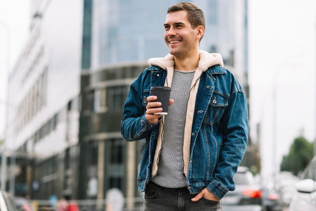 Modern man with coffee cup in urban environment