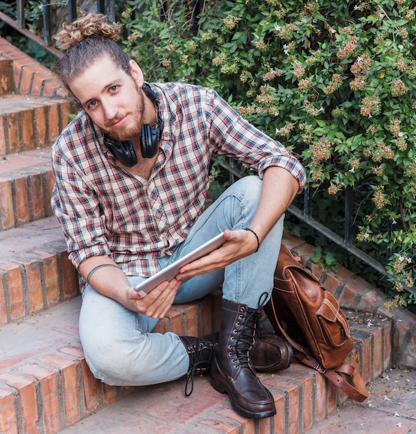 Free photo modern man with tablet on stairs