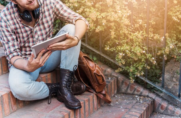 Modern man with tablet on stairs