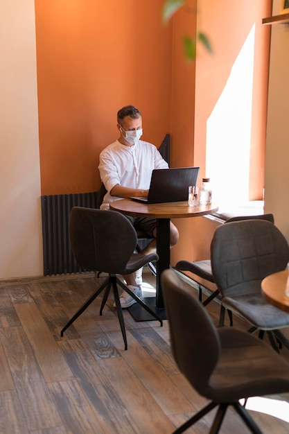 Free photo modern man working on laptop at the office