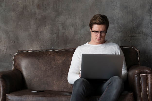 Free photo modern man working on laptop with copy space