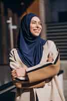 Free photo modern muslim woman wearing headscarf walking in the street