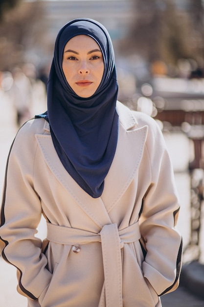 Free photo modern muslim woman wearing headscarf walking in the street