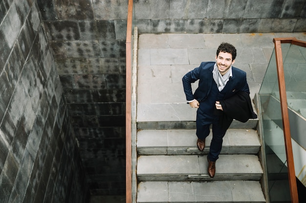 Free photo modern and stylish businessman walking upstairs