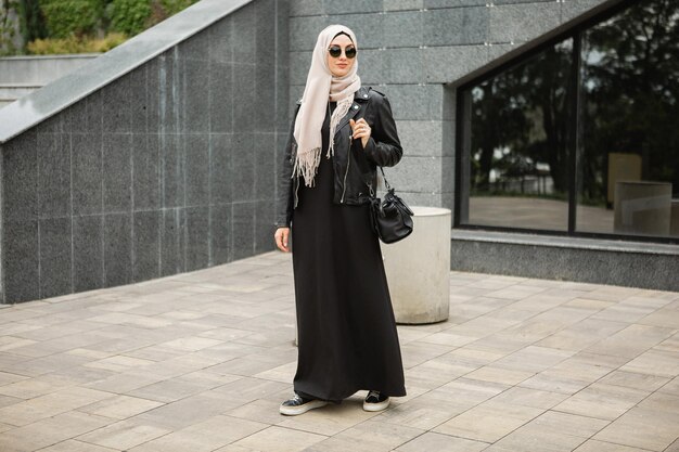 Modern stylish muslim woman in hijab in city street