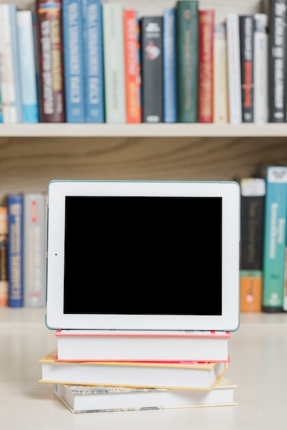 Modern tablet and books in library