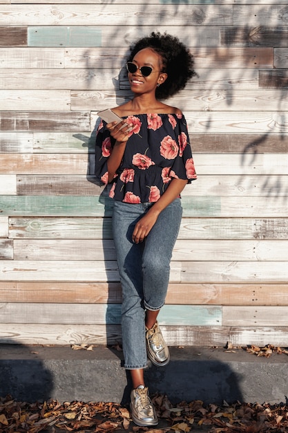 Modern woman holding her phone while looking away