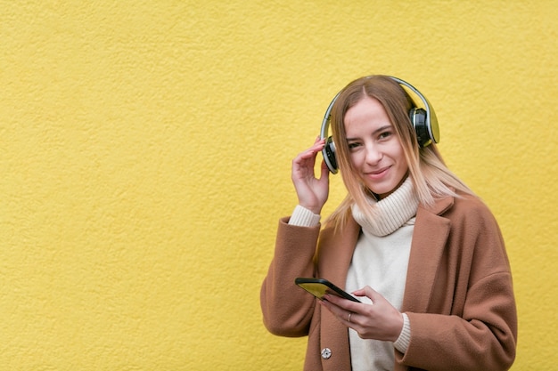 Free Photo modern woman listening to music on headphones with copy space