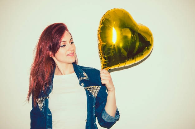 Free Photo modern woman posing with golden balloon