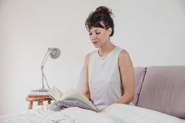 Modern woman reading in the bed