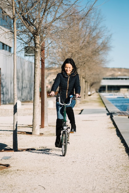 Free photo modern woman riding bike in city