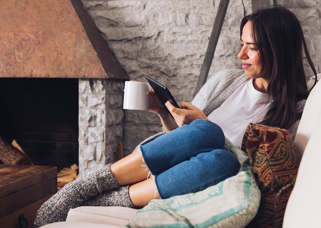 Modern woman sitting on the sofa using a tablet