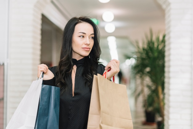 Modern woman with bags in store