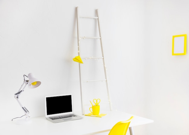 Modern workplace in white and yellow colors with photo frame