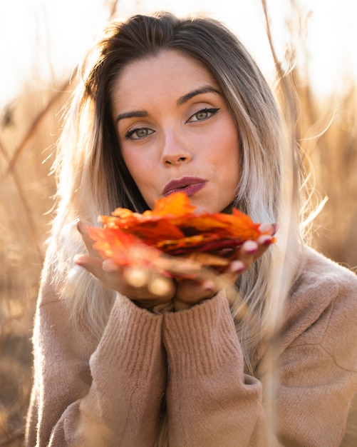 Free Photo modern young woman holding cup of coffee sitting on sofa looking at camera