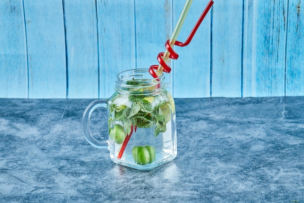 Free Photo mojito cocktail with slices of lime and mint on blue table