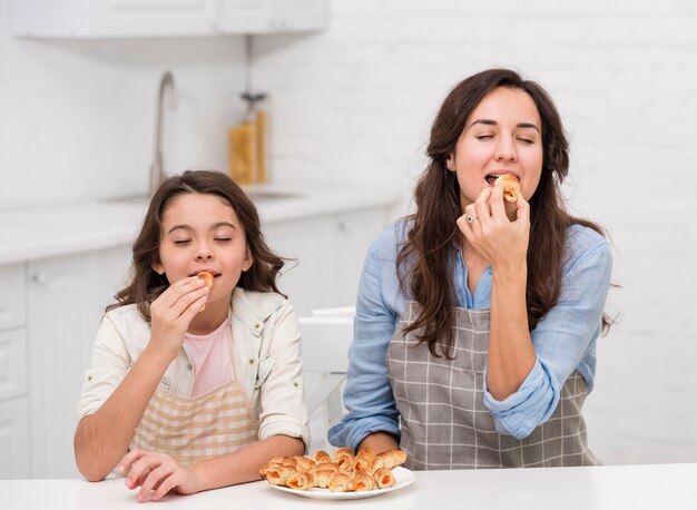 Mom and daughter eating some pastries together