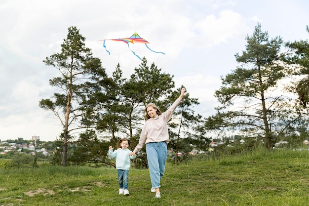 Free photo mom and daughter playing with kite