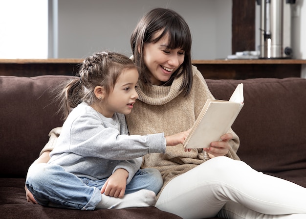 Free photo mom and daughter spend time together reading a book. the concept of children's development and quality time.