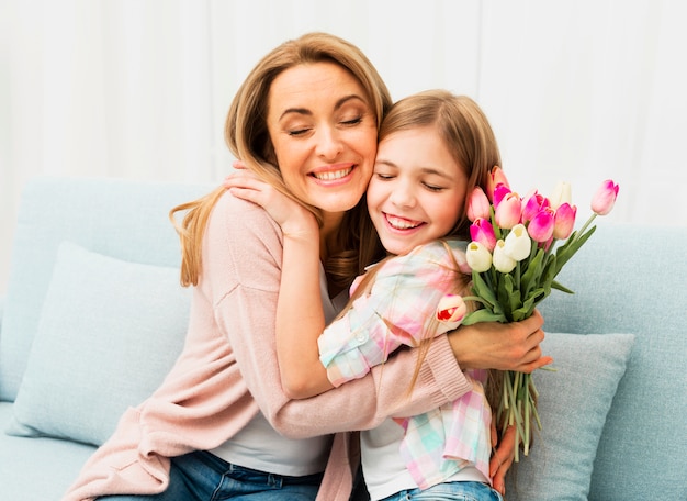 Mom and daughter with satisfied face hugging each other