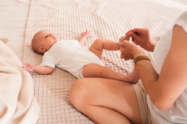 Mom dressing newborn baby close up