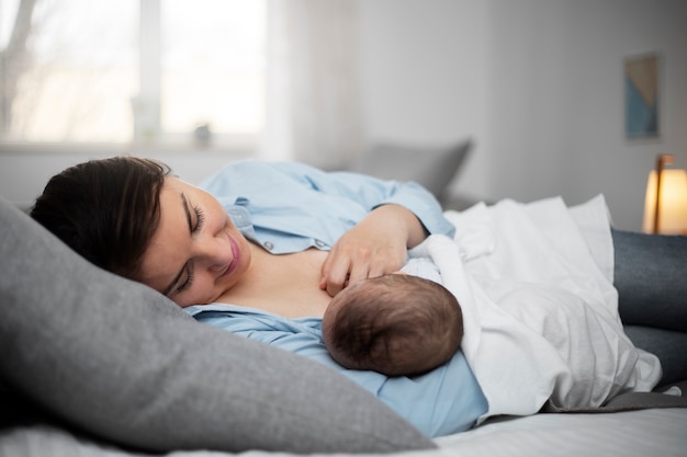 Free photo mom gently breast feeding her child