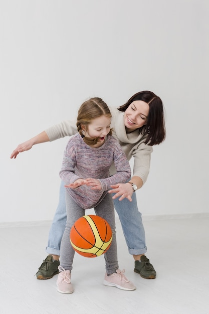 Mom and girl playing basketball