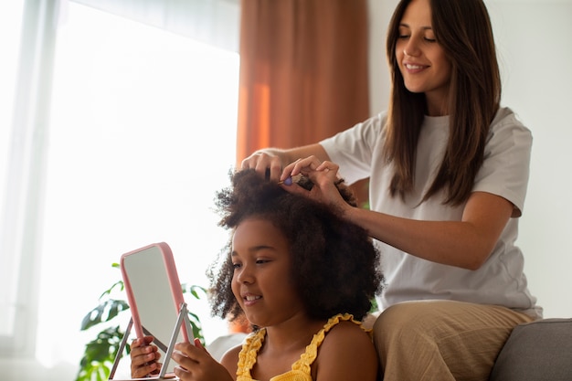 Mom helping her child styling afro hair