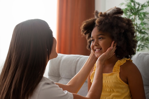 Free photo mom helping her child styling afro hair