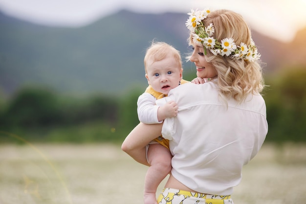 Free photo mom and her kid in camomile field