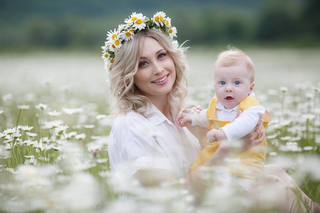 mom and her kid in camomile field