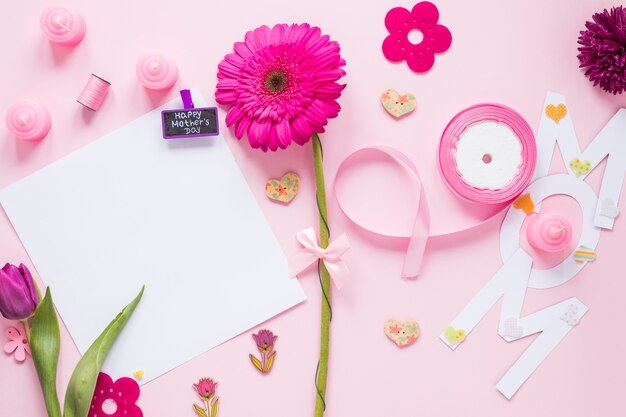 Mom inscription with paper and flowers on table