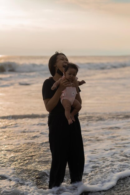 Mom and newborn daughter on the beach