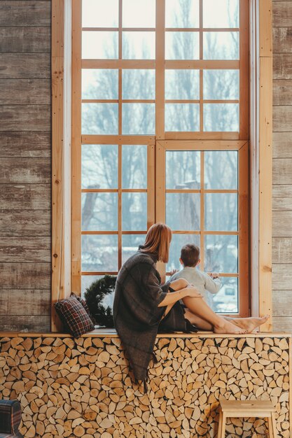 Mom and son sitting on the windowsill and playing.