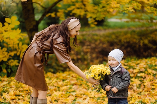 Mom and son walking and having fun together in the autumn park.