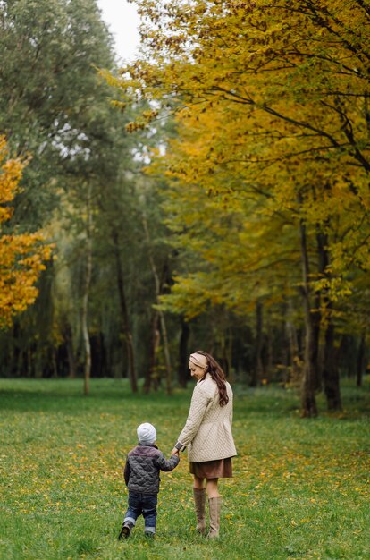 Mom and son walking and having fun together in the autumn park.