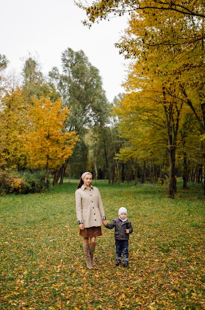 Mom and son walking and having fun together in the autumn park.