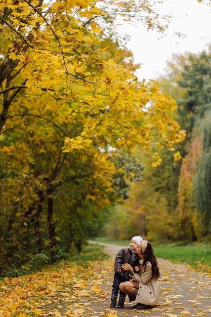 Free Photo mom and son walking and having fun together in the autumn park.