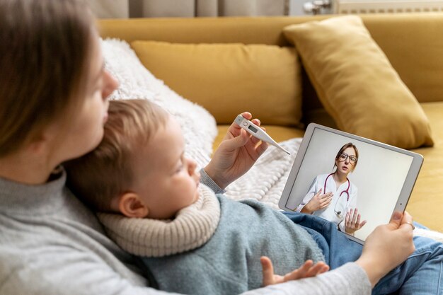 Mom taking care of her child and teleconsulting with doctor