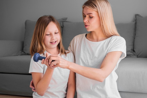 Free Photo mom teaching girl to train with weights