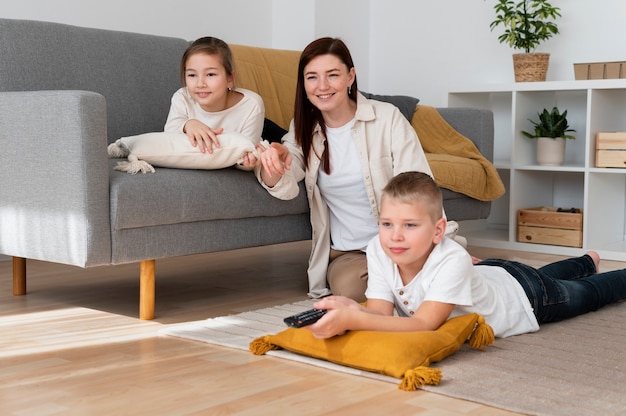 Mom watching television with her children