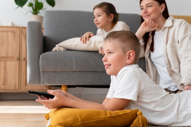 Free photo mom watching television with her children