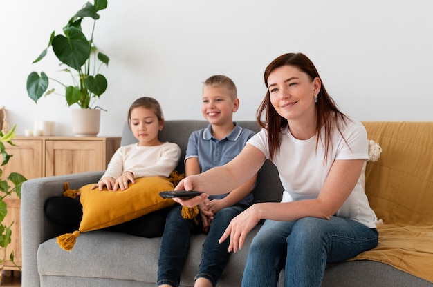 Mom watching television with her children