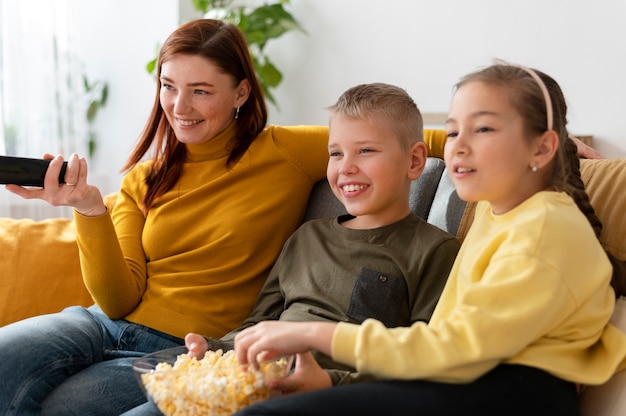 Mom watching television with her children