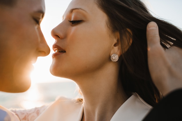 A moment before kiss of a young beautiful caucasian couple on the sunny day outdoors