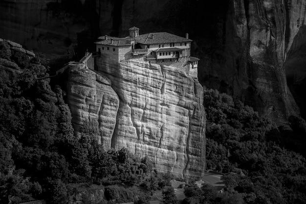 Free photo monastery of the holy trinity on a rock surrounded by forests and hills under sunlight in greece